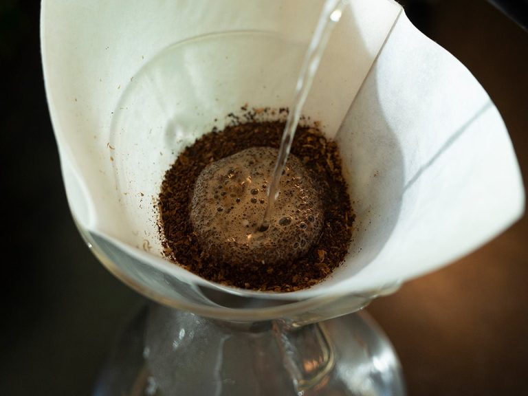 A modern drip coffee maker preparing a fresh pot of coffee in a kitchen.