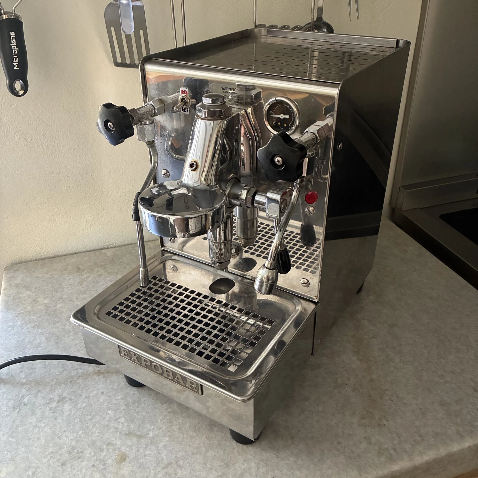A Phillips-head screwdriver and screws laid out for coffee machine port maintenance.