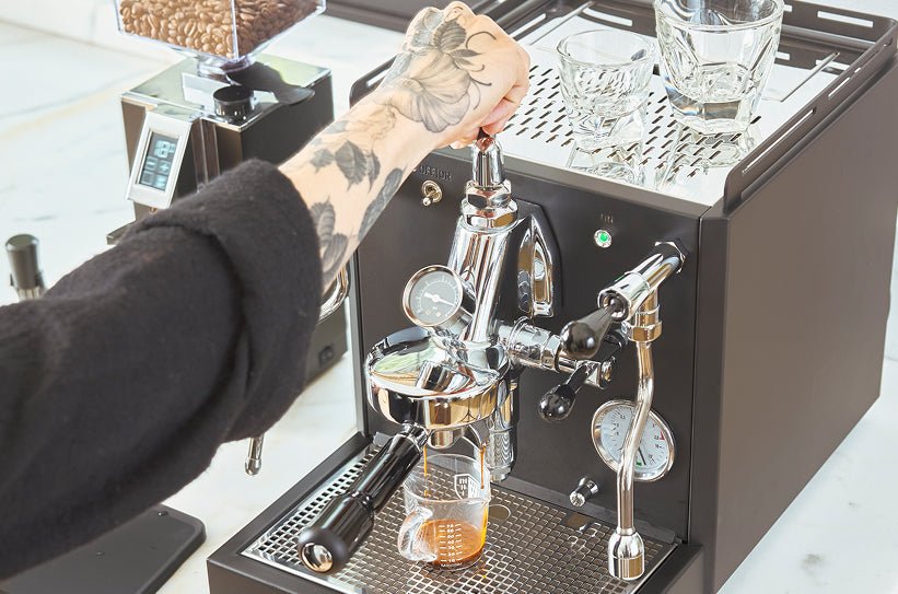 The pressure gauge of an espresso machine shows a steady flow during extraction.