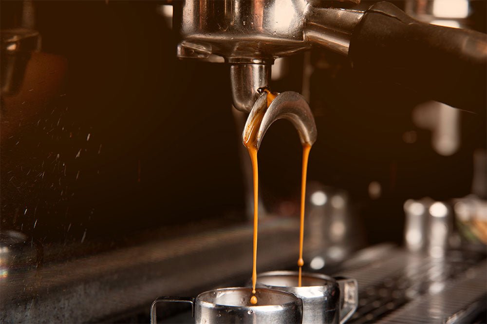A professional barista carefully pulls a rich shot of espresso in a modern cafe.
